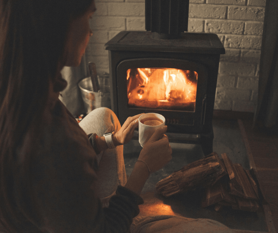 Open Fire at Home woman with hot chocolate next to an open fire